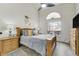 Bright bedroom showcases a ceiling fan, arched window, and a comfortable wooden bed at 4648 S Abilene Cir, Aurora, CO 80015