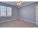 Bright bedroom featuring light hardwood floors, a ceiling fan, and natural light at 12914 Ironstone Way # 201, Parker, CO 80134