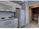 Efficient kitchen with white appliances and adjacent laundry closet at 12914 Ironstone Way # 201, Parker, CO 80134
