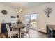 Cozy dining area with access to backyard, wood floors, modern lighting fixture, and stylish decor at 27425 E Byers Pl, Aurora, CO 80018
