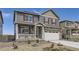 Beautiful two-story home featuring stone accents, a well-manicured yard, a covered porch, and an attached garage at 27425 E Byers Pl, Aurora, CO 80018