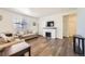 Bright living room featuring a fireplace, large window, neutral decor, and wood-look flooring at 27425 E Byers Pl, Aurora, CO 80018