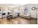 Open concept living area with neutral sofas, wood floors, and a view of the dining area at 27425 E Byers Pl, Aurora, CO 80018