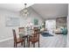 Open concept dining area with glass table, four chairs, and modern lighting fixture at 14396 E Florida Ave # B, Aurora, CO 80012