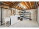 Unfinished basement with laundry hookups and storage shelving at 2054 S Xenia Way # 59, Denver, CO 80231