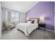 Bright bedroom with a comfortable bed and soothing purple accent wall at 2054 S Xenia Way # 59, Denver, CO 80231