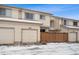 Exterior view of townhouse with attached garage and snow on the ground at 2054 S Xenia Way # 59, Denver, CO 80231