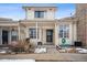 Front view of a light beige townhome with a covered porch and snowy landscaping at 2054 S Xenia Way # 59, Denver, CO 80231