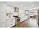 Bright white kitchen featuring stainless steel appliances and hardwood floors at 2054 S Xenia Way # 59, Denver, CO 80231