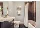 Well lit bathroom with stylish vanity, framed mirror, and shower with brown and beige accent tiles at 1388 Kenton, Aurora, CO 80010