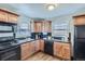 This kitchen features wood cabinets, black appliances, and lots of natural light at 1388 Kenton, Aurora, CO 80010