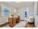 Stylish office with a wooden desk, chair, natural light, and an adjacent sitting area at 1388 Kenton, Aurora, CO 80010