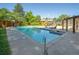 Long pool with built-in spa surrounded by concrete deck, trees and a wood fence at 2636 Juniper Ave # 39-1, Boulder, CO 80304