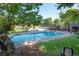Community pool surrounded by lush trees, green grass, lounge chairs and pergolas at 2636 Juniper Ave # 39-1, Boulder, CO 80304
