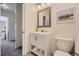 Bathroom featuring a vanity with storage, a framed mirror, and a convenient toilet at 1073 W Powers Ave, Littleton, CO 80120