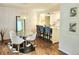 Bright dining area featuring a glass table, modern chandelier, and a view into the kitchen at 1073 W Powers Ave, Littleton, CO 80120