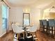 Dining area with a glass table, geometric wallpaper, and adjacent kitchen bar at 1073 W Powers Ave, Littleton, CO 80120