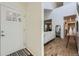 Foyer with coat closet and front door leading to a bright living space with hardwood floors at 1073 W Powers Ave, Littleton, CO 80120