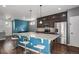 Open-concept kitchen with a large island with bar seating, stainless appliances, and dark cabinets at 20031 Elgin Dr, Denver, CO 80249