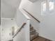 Staircase featuring carpeted steps, wood railings, white walls and a window for natural light at 20031 Elgin Dr, Denver, CO 80249