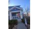 Inviting blue home with a covered front porch, white pillars, and a bright red door at 2793 Roslyn St, Denver, CO 80238