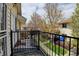Private balcony with black iron railing offers scenic views of the neighborhood's lush greenery and landscaping at 7450 Lowell Blvd # B, Westminster, CO 80030
