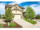 Tan two-story home with a two car garage and a well manicured lawn at 2115 Holmby Ct, Castle Rock, CO 80104
