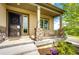 Inviting front porch with decorative columns, plants, and a cozy swing, enhancing the home's charm at 2115 Holmby Ct, Castle Rock, CO 80104