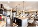 Open-concept kitchen with island seating, chandelier lighting, and hardwood floors flowing into the dining area at 2115 Holmby Ct, Castle Rock, CO 80104