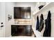 Mudroom featuring dark cabinets, granite countertops, tiled backsplash, and a bench with coat hooks at 2115 Holmby Ct, Castle Rock, CO 80104