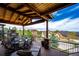 Outdoor deck with stone fireplace, dining set, and lounge seating offering views of the surrounding neighborhood at 2115 Holmby Ct, Castle Rock, CO 80104