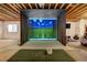 Basement featuring a golf simulator with a large screen, providing an immersive virtual experience at 74 Blue Heron Dr, Greenwood Village, CO 80121