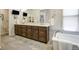 Bathroom featuring a dual sink vanity with wood cabinets, quartz countertop, and decorative rug at 74 Blue Heron Dr, Greenwood Village, CO 80121