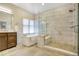 Bright bathroom showcasing a soaking tub with natural light and a glass-enclosed shower with built-in bench at 74 Blue Heron Dr, Greenwood Village, CO 80121