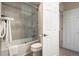 Bathroom with a toilet, bathtub with shower, and a white door leading to another room at 74 Blue Heron Dr, Greenwood Village, CO 80121