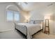 Bedroom with a metal frame bed, carpeted floor, and large arched window with white shutters at 74 Blue Heron Dr, Greenwood Village, CO 80121