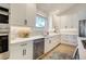 Modern kitchen with white cabinets, stainless steel appliances, and a patterned tile backsplash at 74 Blue Heron Dr, Greenwood Village, CO 80121