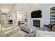 Open-concept living room with a fireplace, TV, built-in shelving and an entry to the foyer at 74 Blue Heron Dr, Greenwood Village, CO 80121
