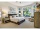 Serene main bedroom filled with natural light from large windows with beautiful wooded views at 74 Blue Heron Dr, Greenwood Village, CO 80121
