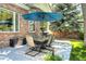 Patio area features a table with seating, a brick wall, and shade from a large umbrella, perfect for gatherings at 74 Blue Heron Dr, Greenwood Village, CO 80121