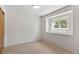 Small, bright bedroom with neutral walls and carpets boasts a large picture window at 1637 S Stuart St, Denver, CO 80219