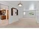Bright living room features neutral carpet, a charming chandelier, and a pass-through to the adjacent kitchen at 1637 S Stuart St, Denver, CO 80219