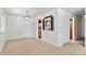 Spacious living room boasts a decorative chandelier, pass-through to the kitchen, and neutral carpet and walls at 1637 S Stuart St, Denver, CO 80219