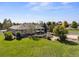 Expansive backyard featuring a patio, lush lawn, mature trees, and a glimpse of the home's exterior at 6449 E 163Rd Ave, Brighton, CO 80602