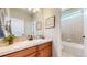 Well-lit bathroom featuring neutral tile, a framed mirror, and a tiled shower at 6449 E 163Rd Ave, Brighton, CO 80602