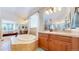 Luxurious bathroom featuring a soaking tub, dual vanities, and tile flooring, as well as a glass shower at 6449 E 163Rd Ave, Brighton, CO 80602