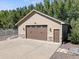 Close-up of a detached garage with a brown door and stone accents at 6449 E 163Rd Ave, Brighton, CO 80602