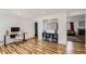 Open-concept living area with wood floors, a decorative bookcase, and neutral wall colors at 2175 E 126Th Way, Thornton, CO 80241