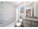 Bright bathroom features a tub shower, stylish vanity, and a window for natural light at 13625 E 103Rd Pl, Commerce City, CO 80022