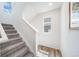 Bright stairway features plush carpeting, white walls and railings, and beautiful wood flooring landing at 13625 E 103Rd Pl, Commerce City, CO 80022